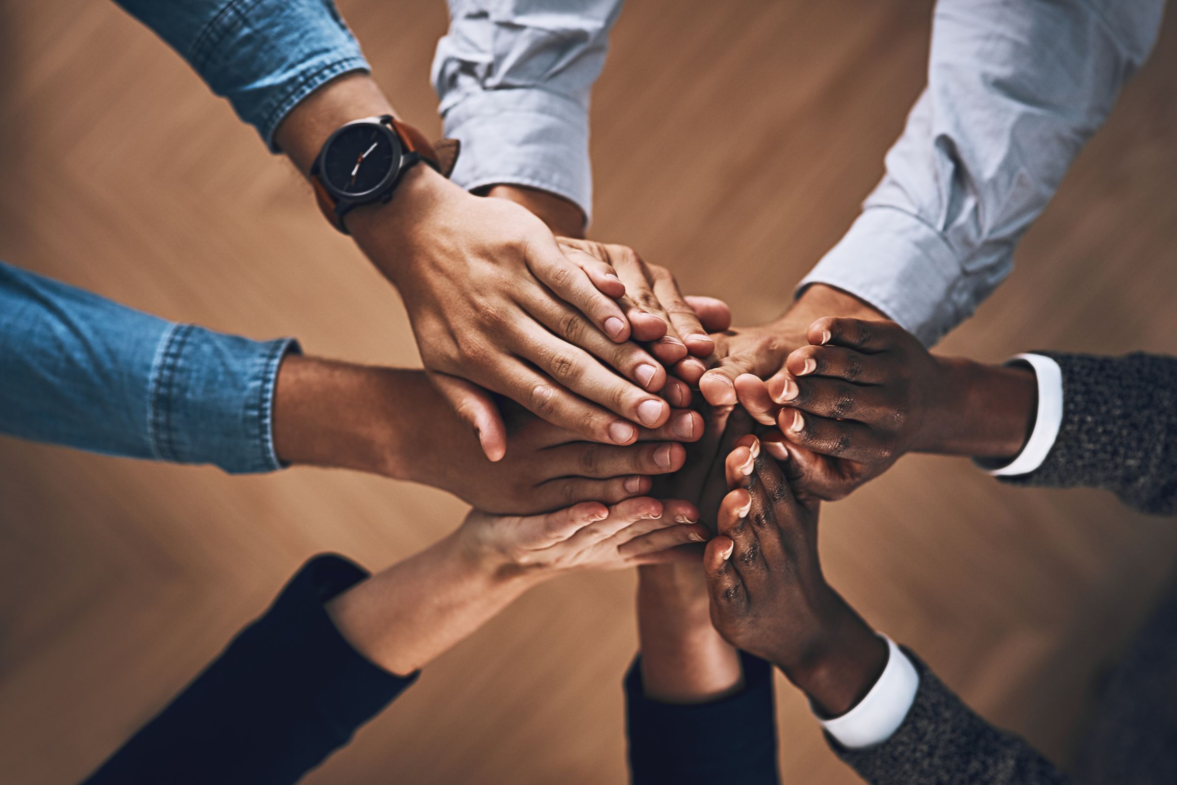 Colleagues joining hands in the middle of a circle